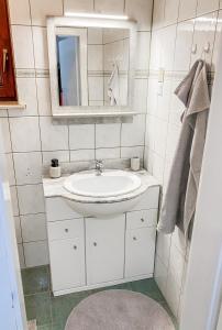 a white bathroom with a sink and a mirror at House Marin - whole house in Maribor