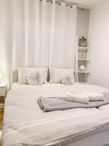 a bedroom with a large bed with white walls at House Marin - whole house in Maribor