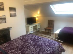 a bedroom with a bed and a desk with a tv at Belfast Duplex Apartment No Parties in Belfast