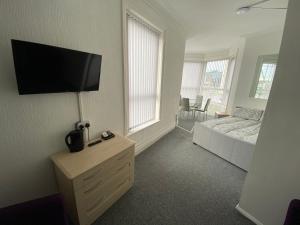 a bedroom with a bed and a tv on the wall at The Honley hotel in Blackpool
