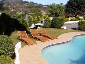 a group of chairs sitting next to a swimming pool at JR Guesthouse in Durban