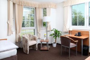 Schlafzimmer mit einem Schreibtisch, einem Stuhl und einem Bett in der Unterkunft Hotel Fürstenberg in Essen