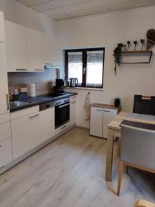 a large kitchen with white cabinets and a table at Holiday Home in Quiet Beautiful Area With Two Separate, Modern, Furnished Apartments in Deutsch-Wagram