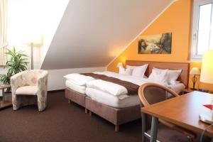 a hotel room with a bed and a table and a chair at Hotel Fürstenberg in Essen