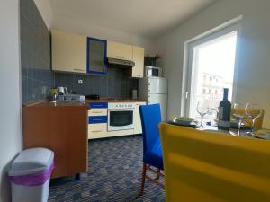 a kitchen with a table and a blue chair at Rooms Jelena in Primošten