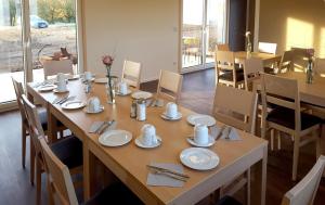 a dining room with a table with plates and utensils at Hollweck´s Landoase in Pilsach