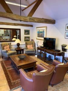 a living room filled with furniture and a flat screen tv at Luxury Cottage & Spa in Guildford