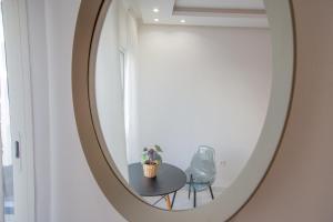 a mirror in a room with a table and a chair at Stayhere Rabat - Agdal 1 - Comfort Residence in Rabat