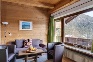 a living room with a couch and a table and a window at Apartmenthaus Jagdhof in Reith bei Seefeld