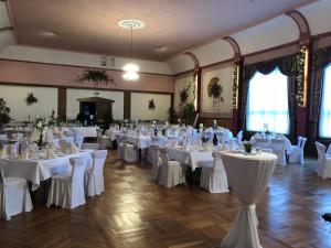 um salão de banquetes com mesas brancas e cadeiras brancas em Hotel-Restaurant Wilhelmsbad em Seesen