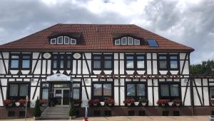 a black and white building with a red roof at Hotel-Restaurant Wilhelmsbad in Seesen