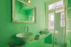 a green bathroom with a sink and a mirror at Casa Blue Sea View, Philian Collection in Skiathos Town +20 photos