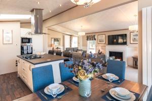 a kitchen and living room with a wooden table with a dining room at Sutton Lodge with Hot Tub in York