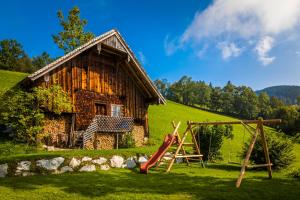 un parque infantil frente a una casa con tobogán en Ferienwohnung Schirla Stub´m en Krispl