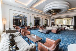 a hotel lobby with couches and chairs and tables at Savoy Le Grand Hotel Marrakech in Marrakech