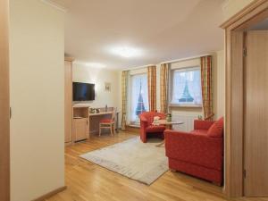 ein Wohnzimmer mit einem roten Sofa und einem Tisch in der Unterkunft Gasthof Belchenblick in Münstertal
