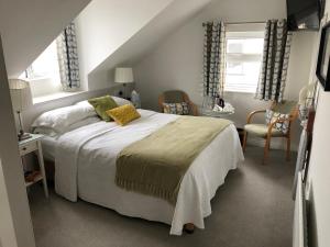 a bedroom with a bed and a chair and windows at Petra House B&B in Galway +15 photos