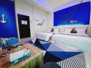 五結鄉的住宿－3Kiss民宿，一间卧室设有两张带蓝色墙壁的床