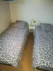 dos camas sentadas una al lado de la otra en un dormitorio en Mobil home climatisé ETANG DE BESSE, en La Parée Preneau
