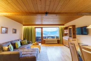 a living room with a couch and a large window at Apartmenthaus Jagdhof in Reith bei Seefeld