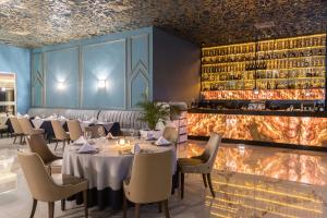 une salle à manger avec des tables, des chaises et une cheminée dans l'établissement Savoy Le Grand Hotel Marrakech, à Marrakech