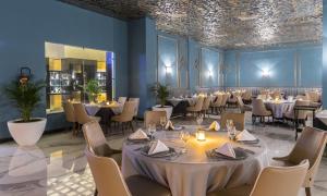 a dining room with tables and chairs and a ceiling at Savoy Le Grand Hotel Marrakech in Marrakech