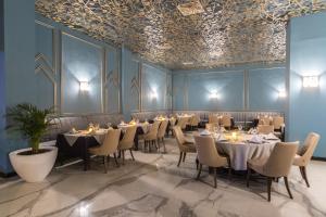 a dining room with tables and chairs and blue walls at Savoy Le Grand Hotel Marrakech in Marrakech