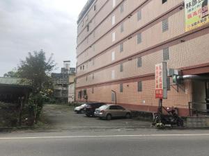 um parque de estacionamento com carros estacionados ao lado de um edifício em Da Fang Hotel em Jiaoxi