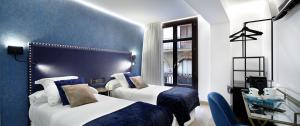 畢爾包的住宿－Pension Ama Bilbao，酒店客房设有两张床和窗户。
