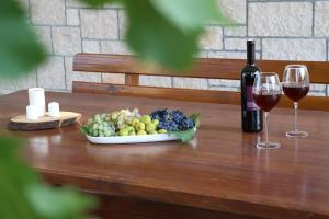 Una mesa con un plato de uvas y una botella de vino. en Stone Villa Olea, en Supetar 35 fotos más