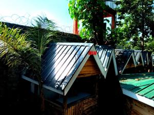 a building with a roof with a sign on it at Vienna Woods Hotel Nakuru in Nakuru