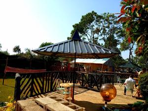 a pavilion with a table and chairs in a park at Vienna Woods Hotel Nakuru in Nakuru