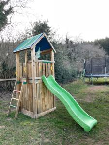 a wooden playground with a slide and a ladder at Les Perruchons ancienne grange rénovée avec soin in Ozolles
