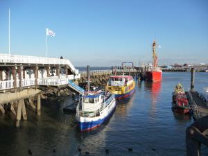 a group of boats docked next to a dock at Pension Döser Strand in Cuxhaven