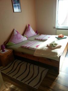 a bedroom with a bed with pink pillows at Pension Döser Strand in Cuxhaven