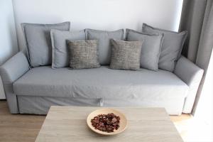 a couch with pillows and a bowl on a table at Superb seaview apartment in Playa de Las Americas in Playa de las Americas