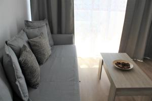 a couch with pillows and a table in a room at Superb seaview apartment in Playa de Las Americas in Playa de las Americas