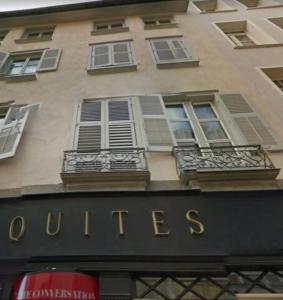 un edificio con una señal para un edificio con ventanas en STUDIO cosy dans le centre de LIMOGES, en Limoges