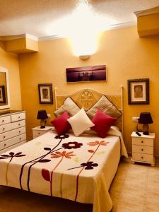 a bedroom with a large bed with red pillows at Vera Natura Urbanizaci&oacute;n Naturista in Vera