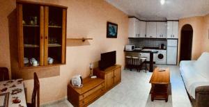 a living room with a couch and a table and a kitchen at Vera Natura Urbanización Naturista in Vera