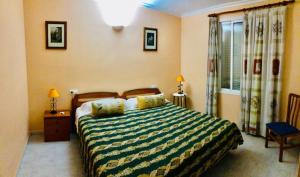 a bedroom with a bed with a green and yellow striped blanket at Vera Natura Urbanización Naturista in Vera +10 photos
