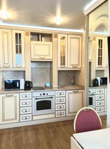 a kitchen with white cabinets and a stove at Apartments Gorskiy in Novosibirsk
