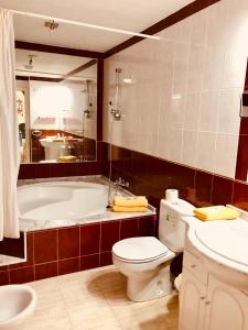 a bathroom with a tub and a toilet and a sink at Vera Natura Urbanización Naturista in Vera