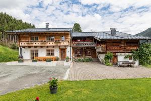 a large wooden house with a patio in front of it at Maroldenhof in Saalbach Hinterglemm