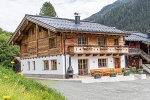 a large wooden house with a bench in front of it at Maroldenhof in Saalbach Hinterglemm