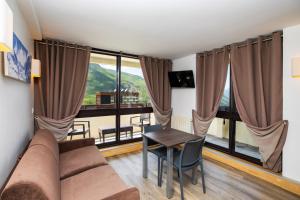 a living room with a couch and a table at SOWELL RESIDENCES Crêt Voland in Les Menuires