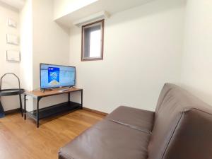 a living room with a couch and a television on a table at Otsuka No 4 Mansion in Tokyo