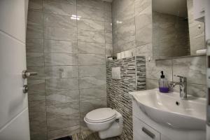 a bathroom with a white toilet and a sink at Rooms DRAGICA in Pakoštane
