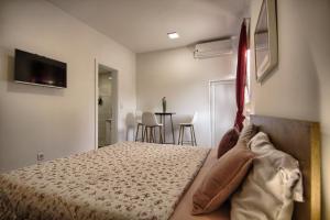 a bedroom with a bed and a table with chairs at Rooms DRAGICA in Pakoštane