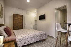 a small bedroom with a bed and a chair at Rooms DRAGICA in Pakoštane